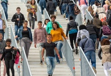 a crowd of people walk up and down ourtdoor stairs
